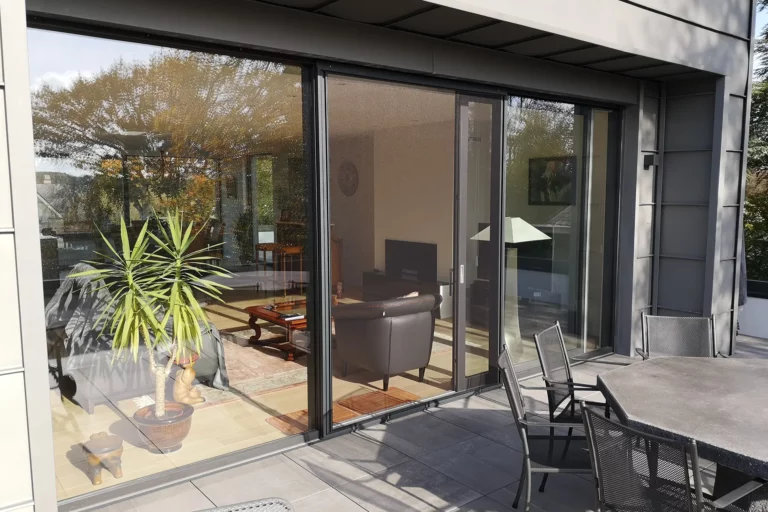 porte-moustiquaire-coulissante-sur-mesure-aluminium-feneko-sans-traverse-coloris-ral-9005-noire-toile-clearview-entrouverte-vue-exterieure-hdo-histoires-d-ombres-bruxelles-nivelles